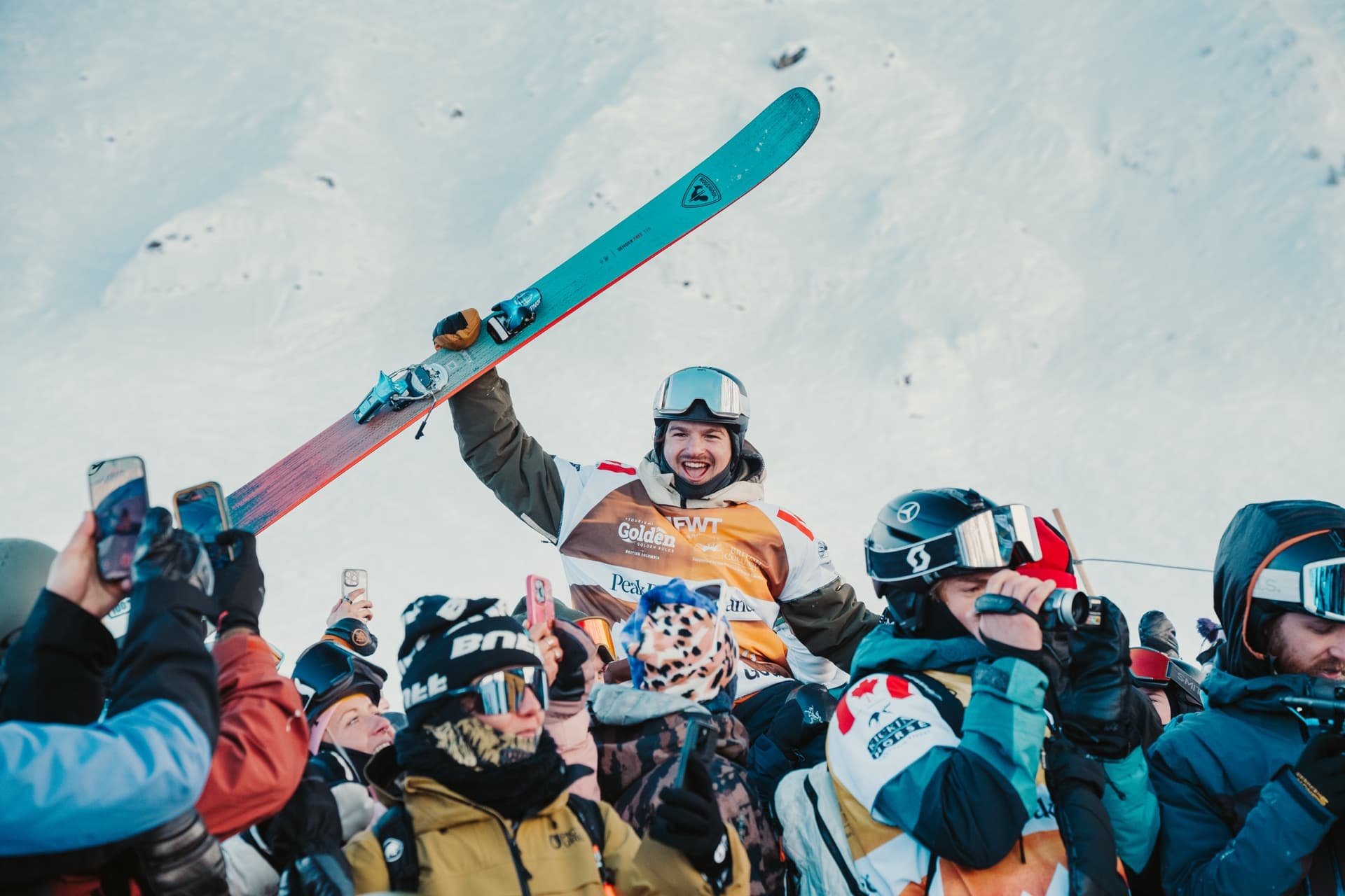 Skiers packed together at the bottom of a run with their phones up