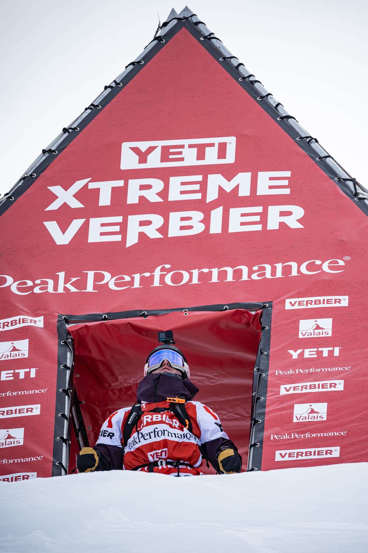 A rider in the start gate under the YETI Xtreme Verbier arch
