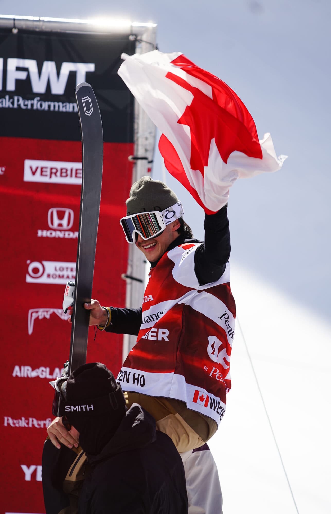 A rider waving a Canadian flag in the Verbier finish area